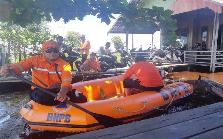 Petugas BPBD Pulang Pisau naik perahu karet di lokasi banjir
