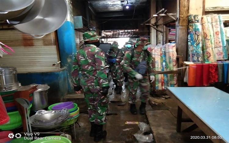 Anggota Kodim 1016 Palangka Raya menyemprotkan cairan disinfektan ke lorong Pasar Besar