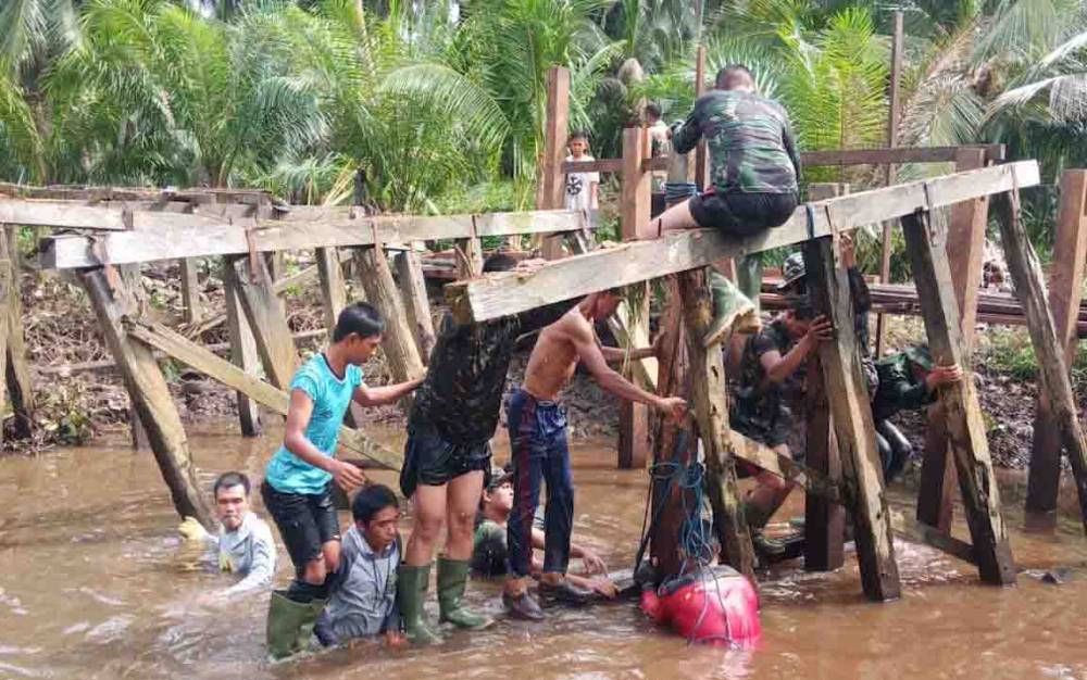 Personel Satgas TMMD bersama TNI bersatu mengerjakan pembangunan jembatan di Kecamatan Pulau Hanaut.