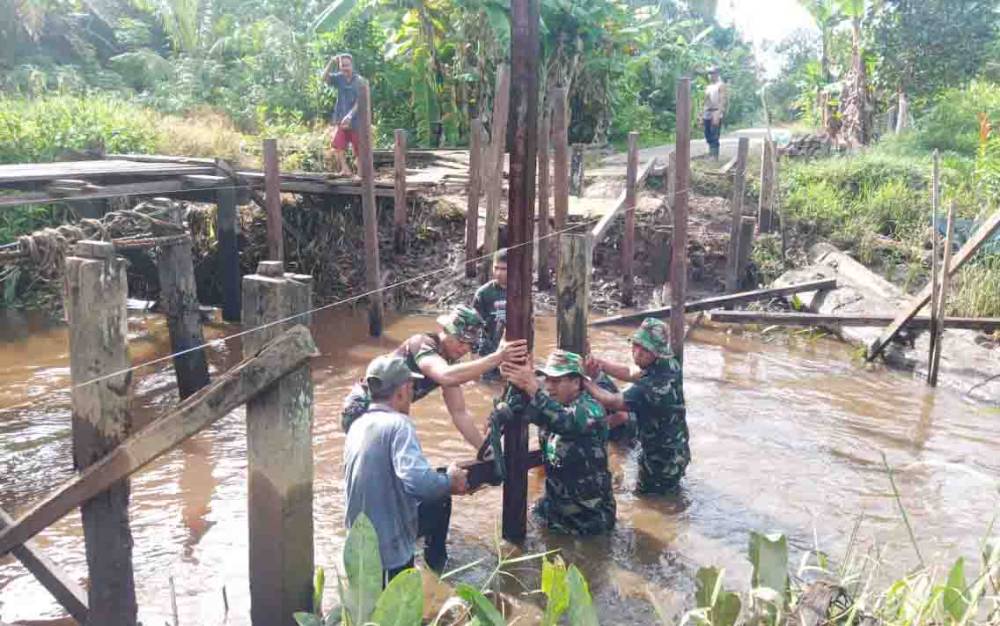 Kebersamaan personel Satgas TMMD dan warga saat membangun jembatan di Kecamatan Pulau Hanaut.
