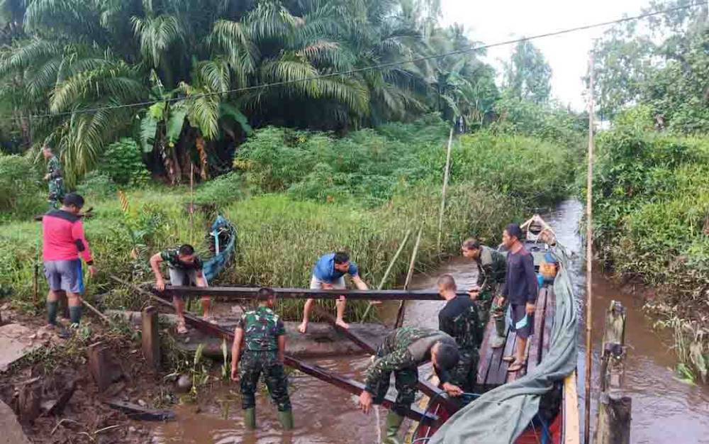Proses mobilisasi bahan bangunan untuk perbaikan jembatan di Kecamatan Pulau Hanaut. (foto : Dok Kodim 1015 Sampit)