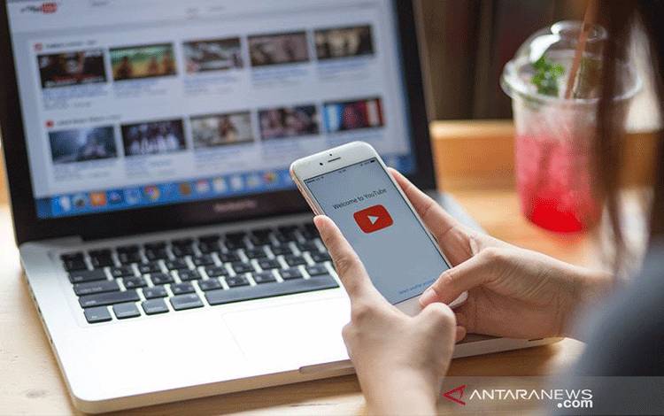 Ilustrasi - Wanita memegang Smartphone dengan layanan video YouTube di layar. ANTARA/Shutterstock/pri.