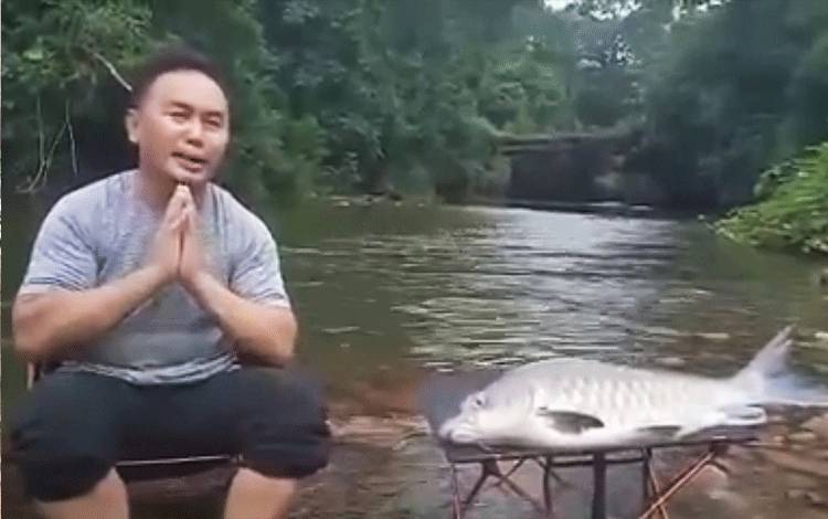 Gubernur Kalimantan Tengah Sugianto Sabran sedang bersantai di tepi sungai saat mengucapkan selamat kepada masyarakat dalam akun facebooknya.