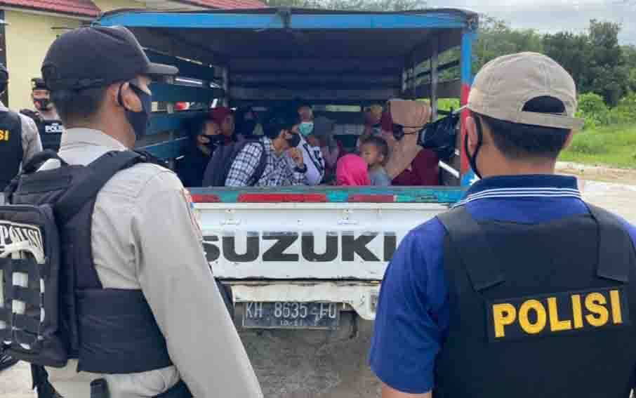 Polisi menghentikan pikap yang kedapatan mengangkut penumpang di bak, di jalur menuju Pantai Ujung Pandaran, Minggu, 3 Januari 2021.