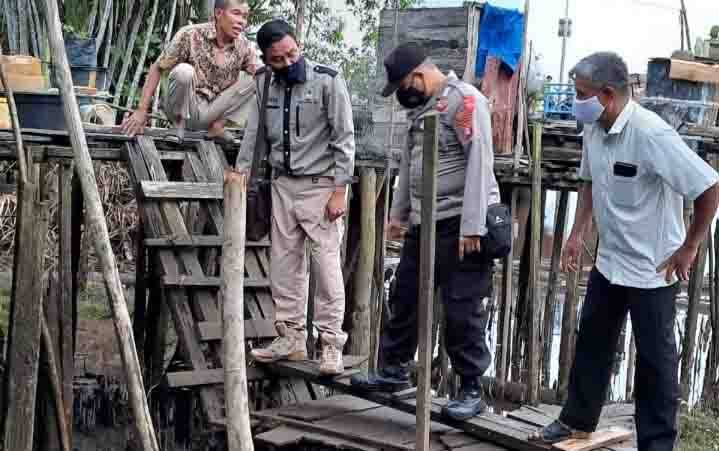 Komandan BKSDA Pos Jaga Sampit, Muriansyah (2 dari kiri) bersama anggota polisi dan keluarga korban saat melihat lokasi serangan buaya.