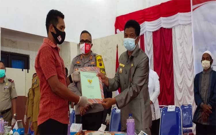 Wabup Sukamara, Ahmadi menyerahkan sertifikat tanah secara simbolis kepada perwakilan masyarakat