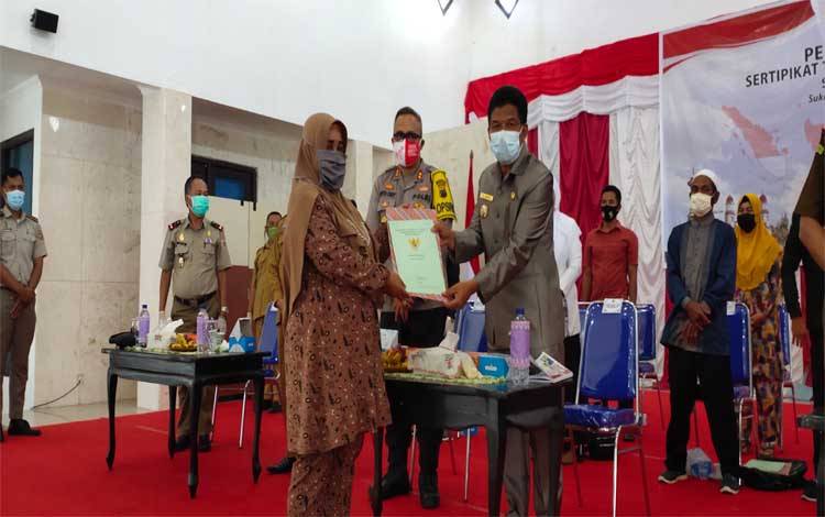 Wabup Sukamara, Ahmadi menyerahkan sertifikat tanah secara simbolis kepada perwakilan masyarakat