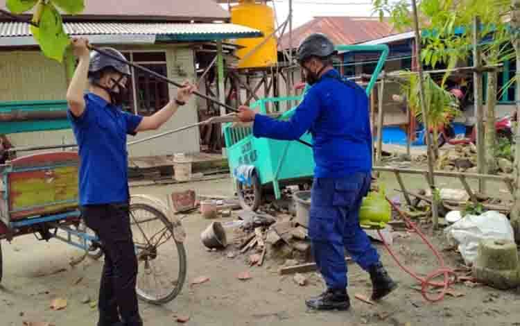 Sejumlah petugas saat mengevakuasi sarang tawon di permukiman warga, Rabu, 6 Januari 2021.
