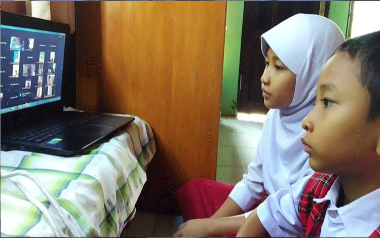 Dua pelajar MIN 3 Palangka Raya sedang mengikuti pembukaan pembelajaran melalui zoom meeting.