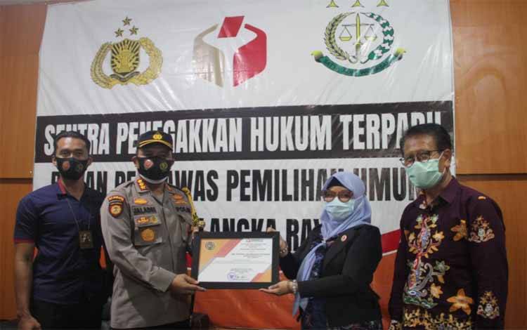 Kapolresta Palangka Raya Kombes Dwi Tunggal Jaladri saat menerima piagam penghargaan dari Ketua Bawaslu Endrawati