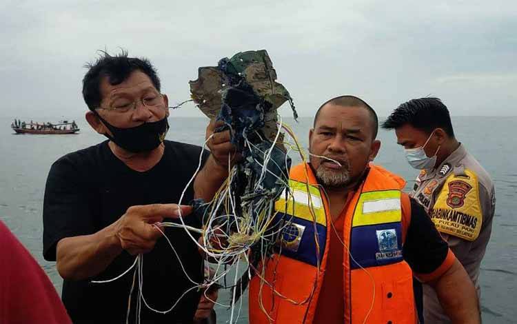 Petugas menunjukkan kabel dan serpihan yang diduga milik pesawat Sriwijaya Air di Pulau Laki, Kepulauan Seribu, Sabtu (9/1/2021)
