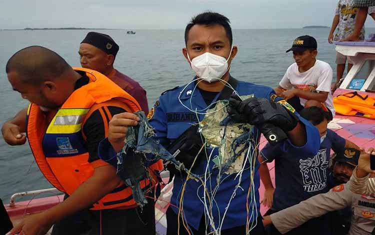 Petugas gabungan mengevakuasi serpihan diduga milik pesawat Sriwijaya Air SJY 182 di Pulau Laki, Kepulauan Seribu, Sabtu (9/1/2021)
