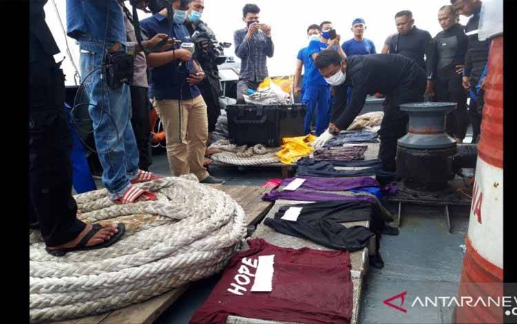 Petugas memeriksa sejumlah barang yang diduga milik penumpang dan pramugari pesawat Sriwijaya Air yang ditemukan di sekitar perairan Pulau Laki