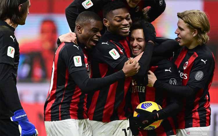 Para pemain AC Milan merayakan keberhasilan Hakan Calhanoglu (kedua dari kanan) mengeksekusi penalti pada pertandingan Piala Italia melawan Torino yang dimainkan di Stadion San Siro, Milan, Selasa (12/1/2021)
