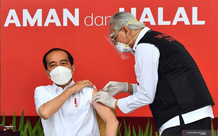 Presiden Joko Widodo (kiri) disuntik dosis pertama vaksin COVID-19 produksi Sinovac oleh vaksinator Wakil Ketua Dokter Kepresidenan Prof Abdul Mutalib (kanan) di beranda Istana Merdeka, Jakarta, Rabu (13/1/2021). Penyuntikan perdana vaksin COVID-19 ke Presiden Joko Widodo tersebut menandai dimulainya program vaksinasi di Indonesia. (ANTARA FOTO/HO/Setpres-Agus Suparto/wpa/hp.)