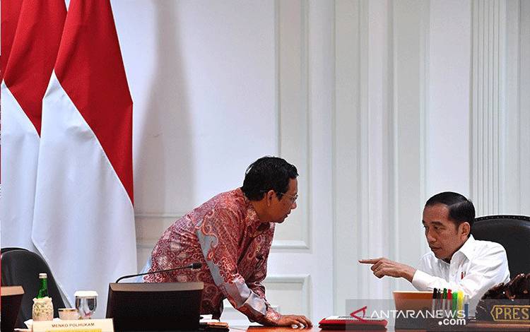 Presiden Joko Widodo berbincang dengan Menko Polhukam Mahfud MD sebelum memimpin rapat kabinet terbatas di Kantor Presiden, Jakarta, Rabu (12/2/2020). ANTARA FOTO/Sigid Kurniawan/wsj/aa.