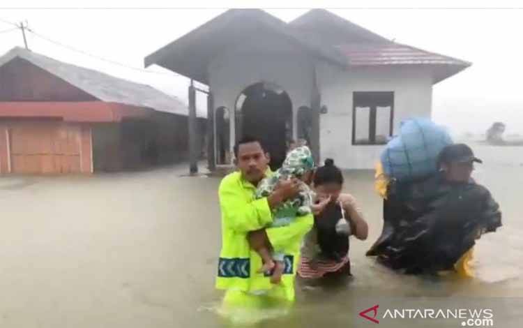 Anggota Satlantas Polres Tanah Laut melakukan evakuasi terhadap seorang bayi di lokasi banjir Desa Pandahan, Kecamatan Bati-Bati