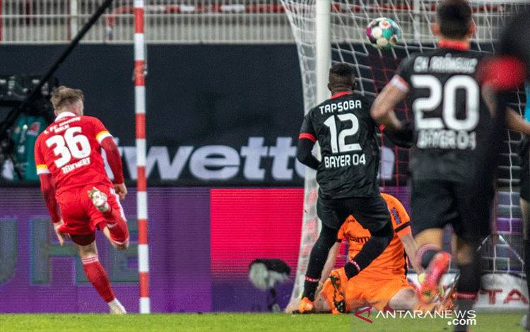 Penyerang Union Berlin Cedric Teuchert (kiri) mencetak gol ke gawang Bayer Leverkusen dalam pertandingan Liga Jerman di Berlin pada Jumat (15/1/2021). (AFP/ANDREAS GORA)