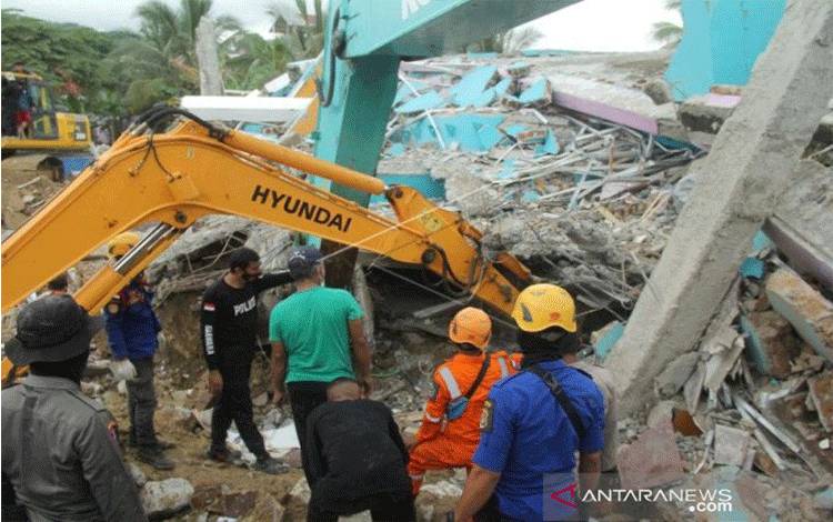 Sejumlah petugas dengan alat berat mencari korban di Rumah Sakit Mitra Manakarra yang runtuh akibat gempa bumi, di Mamuju, Sulawesi Barat, Kamis (15/1/2021). ANTARA FOTO/ Akbar Tado/hp.