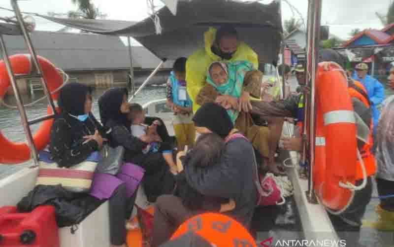 Anggota Polres Tanah Laut bersama tim SAR gabungan mengevakuasi warga korban banjir di Kecamatan Kurau. (foto : ANTARA/Polrestanahlaut)