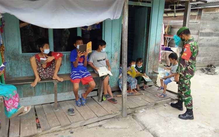 Anak warga Kelurahan Kumai Hulu antusias membaca buku yang dibawa Sikomos