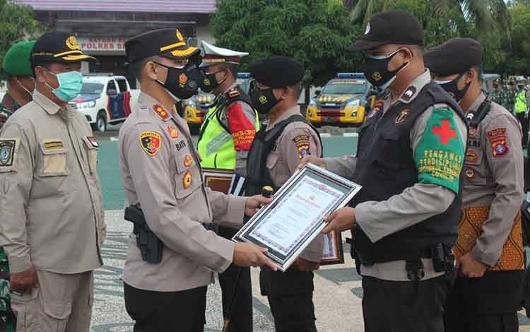 Kapolres Seruyan AKBP Bayu Wicaksono menyerahkan penghargaan kepada salah satu personel