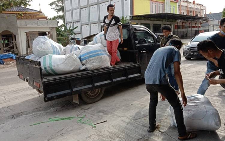 Sejumlah pemuda memasukan pakaian yang dikumpulkan untuk bantuan korban banjir di Kalsel.