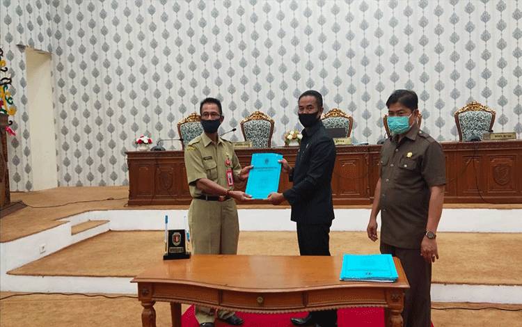 Ketua DPRD Katingan Marwan Susanto didampingi Wakil Ketua Nanang Suriansyah menyerahkan dokumen laporan hasil rapat kerja kepada Asisten I Setda Katingan Edrianto.