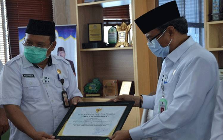 Kepala BPKA Provinsi Kalteng H Nuryakin saat menyerahkan piagam penghargaan Kanwil Kemenag Provinsi Kalteng H Abdul Rasyid