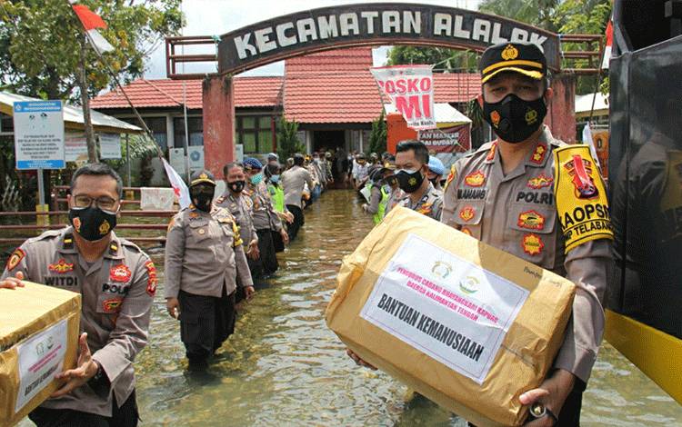 Kapolres Kapuas AKBP Manang Soebeti saat menyalurkan bantuan sosial untuk warga terdampak banjir di Alalak, Batola, Kalsel pada Jumat, 22 Januari 2021.