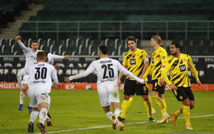 Para pemain Borussia Moenchengladbach (kaus putih) merayakan gol keempat mereka ke gawang Borussia Dortmund pada pertandingan Liga Jerman yang dimainkan di Stadin Borussia Park, Moenchengladbach, Jumat (22/1/2021)