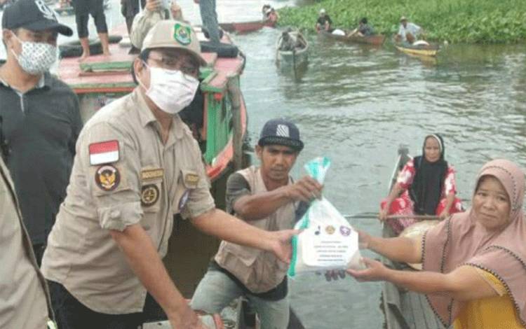 Ketua Kwarcab Gerakan Pramuka Kapuas, Suwarno Muriyat saat menyalurkan bantuan ke warga terdampak banjir di Kalsel.