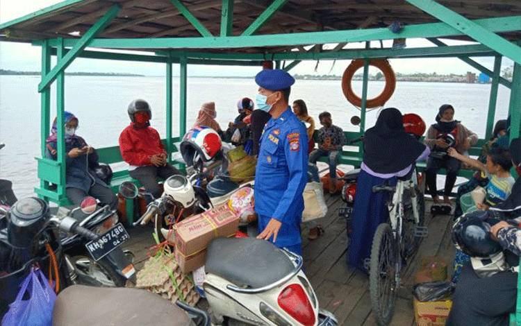 Personel Satpolair Polres Kapuas saat memberikan imbauan protokol kesehatan kepada masyarakat di feri penyeberangan.