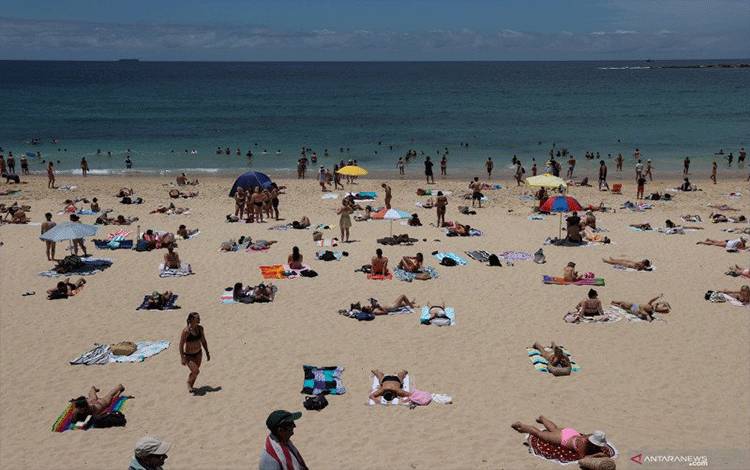 Para pengunjung pantai menikmati hari musim panas di Coogee Beach, saat wabah penyakit virus corona (COVID-19) masih merebak, di Sydney, Australia,  Rabu (13/1/2021). ANTARA FOTO/Reuterss-Loren Elliott/hp.
