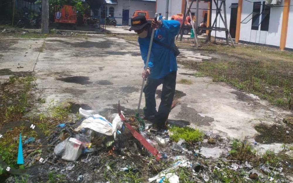 Relawan Satgas Covid-19 Provinsi Kalteng bersih-bersih di halaman pusdalops, Sabtu, 6 Februari 2021.