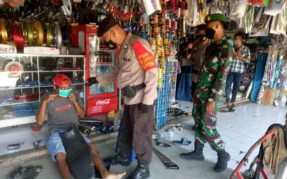 Personel Polsek Pangkalan Banteng bersama anggota TNI menegur warga tidak menggunakan masker.