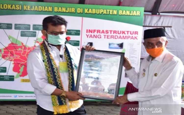Menteri Pertanian Syahrul Yasin Limpo (SYL) menerima cinderamata berupa koran mini dari Bupati Banjar Khalilurrahman saat kunjungan kerja dalam rangka penyerahan bantuan Presiden Jokowi dan bantuan dari Kementan untuk korban banjir di Provinsi Kalsel