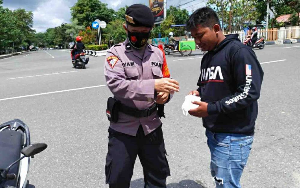 Personel Polres Kapuas saat memberikan masker kepada warga di Kota Kuala Kapuas pada Senin 15 Februari 2021
