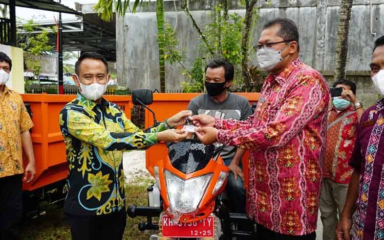 Wali Kota Palangka Raya Fairid Naparin menyerahkan kendaraan roda tiga di Kelurahan Langkai