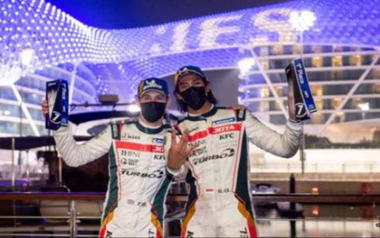 Pebalap Indonesia Sean Gelael (kanan) bersama pebalap asal Inggris Tom Blomqvist (kiri) mengangkat tropi setelah membawa tim JOTA Sport menjadi juara pada ajang Asian Le Mans Series (ALMS) 2021 seri tiga di Sirkuit Yas Marina, Abu Dhabi, Uni Emirat Arab, Jumat (19/2/2021)