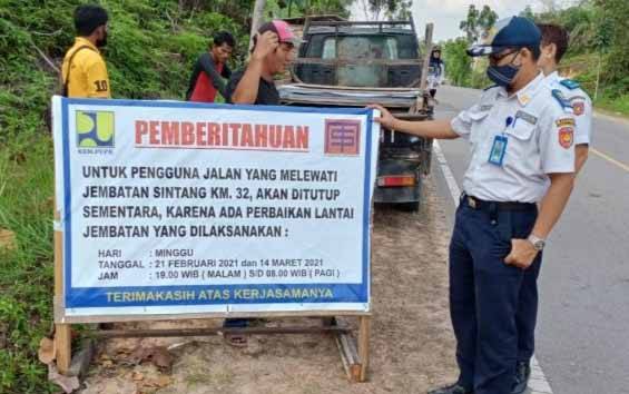 Dishub Kobar memasang pengumuman mengenai rencana penutupan sementara akses Jalan Trans Kalimantan Kobar - Lamandau karena adanya perbaikan lantai Jembatan Sintang pada Minggu, 21 Februari 2021.