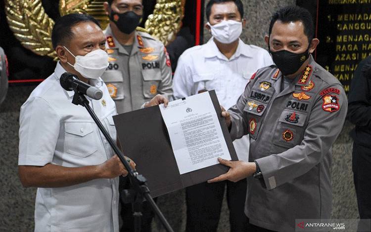 Kapolri Jenderal Pol Listyo Sigit Prabowo (kanan) menyerahkan surat izin keramaian kepada Menpora Zainudin Amali (kiri) usai melakukan pertemuan di Mabes Polri, Jakarta, Kamis (18/2/2021). . ANTARA FOTO/Hafidz Mubarak A/wsj.