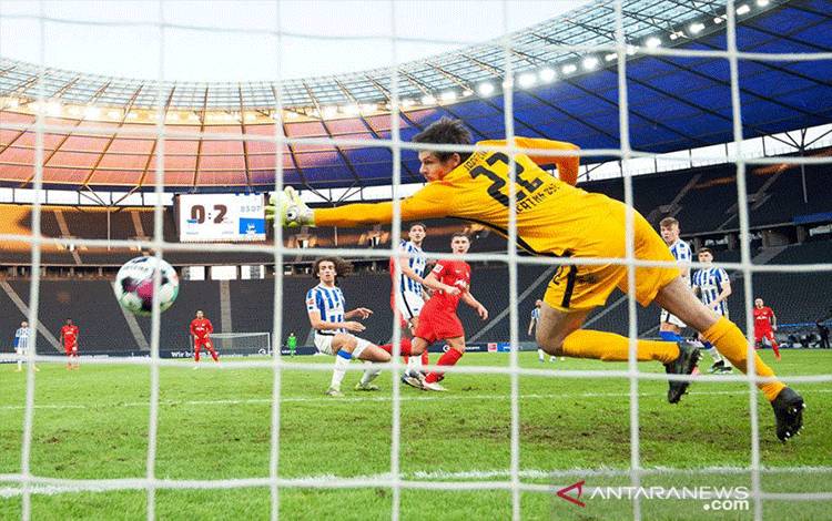 Pemain RB Leipzig (kaus merah) mencetak gol ke gawang Hertha Berlin, pada pertandingan Liga Jerman yang dimainkan di Olympiastadion, Berlin, Minggu. (21/2/2021). (ANTARA/Pool via REUTERS/ANNEGRET HILSE)