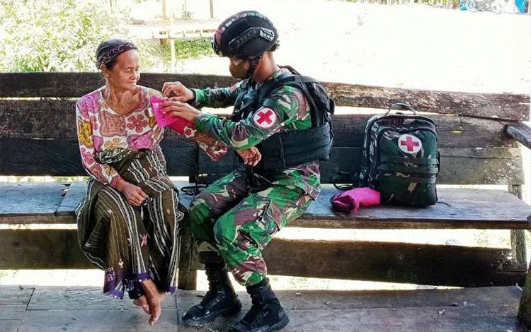 Personel Satgas TNI Yonif Raider 100/PS sedang memberikan layanan kesehatan warga di perbatasan RI-PNG di Kampung Oiyawi distrik Mannem Kabupaten Keerom.(ANTARA News Papua/HO-Pendam XVII/Cenderawasih)