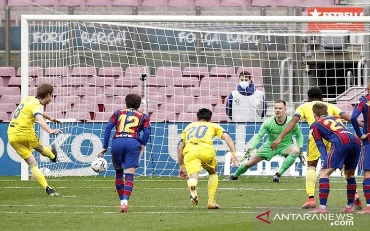 Pemain Cadiz Alex Fernandez (kiri) mengeksekusi penalti pada pertandingan Liga Spanyol melawan Barcelona yang dimainkan di Stadion Nou Camp, Barcelona, Minggu (21/2/2021). (ANTARA/REUTERS/ALBERT GEA)