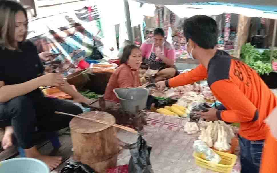 Salah satu personel Satgas Covid-19 Kalteng sedang memberikan masker kepada salah satu pedagang di Pasar PU