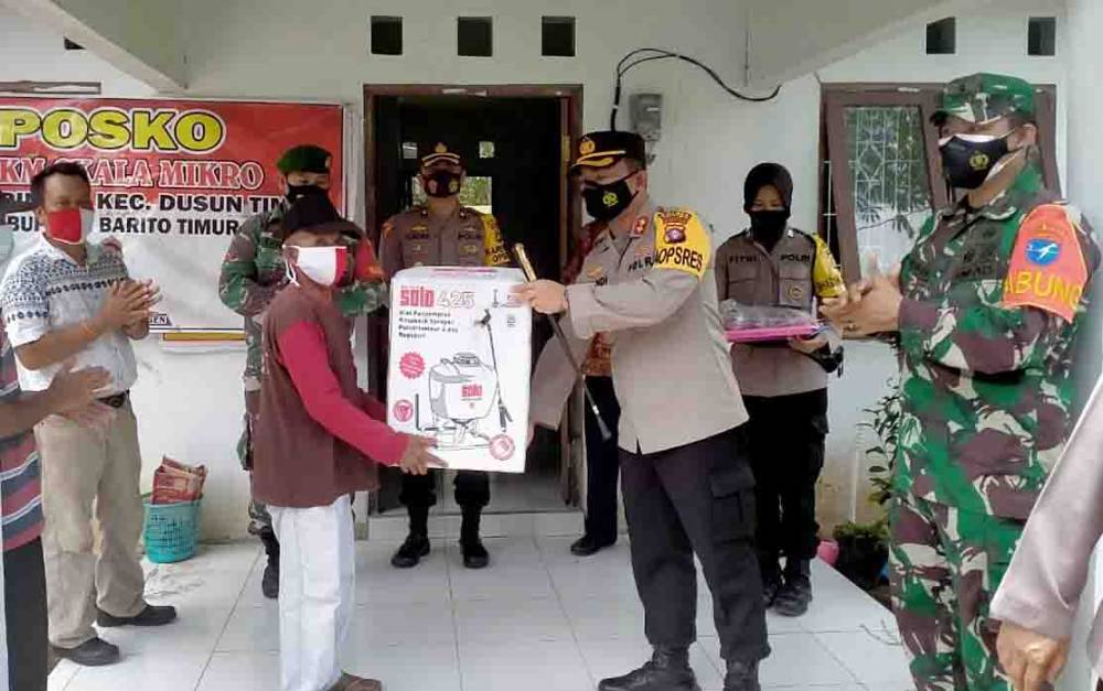 Kapolres Barito Timur Afandi Eka Putra menyerahkan bantuan alat semprot gendong untuk posko PPKM Mikro di Desa Haringen