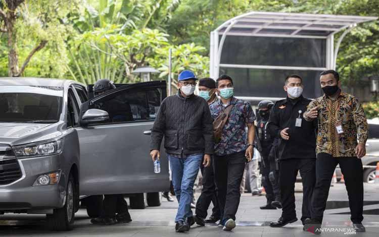 Gubernur Sulawesi Selatan Nurdin Abdullah (kiri) dikawal petugas setibanya di gedung KPK, Jakarta, Sabtu (27/2/2021). KPK mengamankan NurdinAbdullahmelalui Operasi Tangkap Tangan (OTT) bersama lima orang lainnya dengan barang bukti sebuah koper berisi uang. 