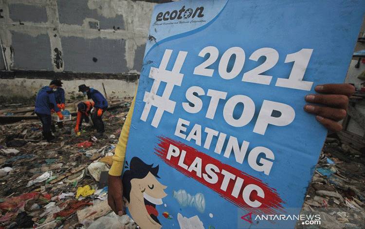 Aktivis lingkungan memunguti sampah plastik saat mengkampanyekan #2021stopmakanplastik di pesisir Kenjeran, Surabaya, Jawa Timur, Kamis (25/2/2021).  ANTARA FOTO/Didik Suhartono/aww.