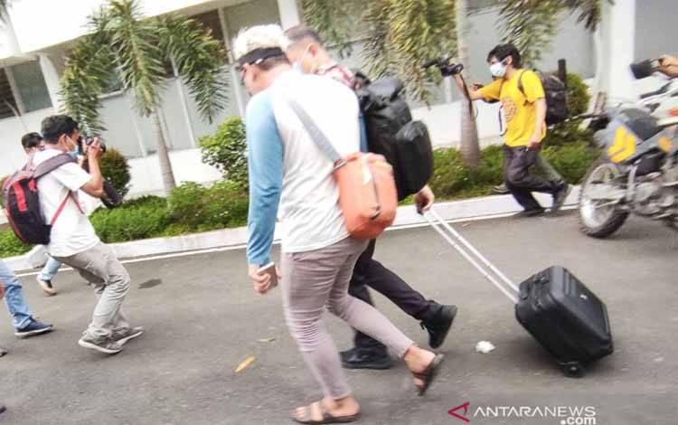 Penyidik KPK (kanan) diapit wartawan sesaat membawa koper barang bukti usai mengeledah Kantor Dinas PUPR Sulawesi Selatan, di Jalan Andi Pangeran Pettarani, Makassar, Sulawesi Selatan, Selasa (2/3/2020)